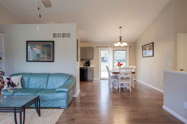 living room with ceiling fan with notable chandelier, dark hardwood / wood-style flooring, and vaulted ceiling