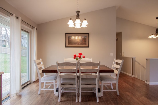 dining space with hardwood / wood-style flooring, a notable chandelier, and lofted ceiling