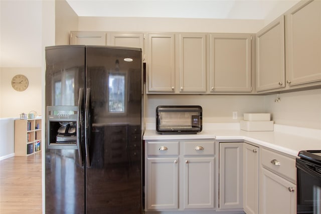 kitchen with light wood-type flooring, gray cabinets, and black appliances