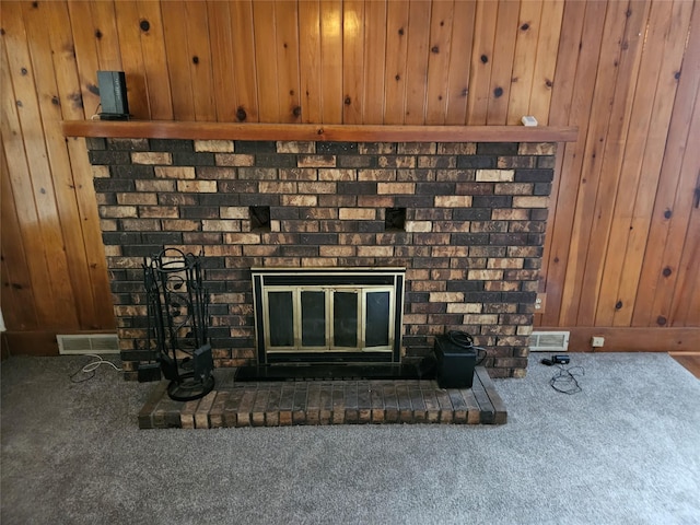 room details featuring carpet flooring, a fireplace, and wooden walls