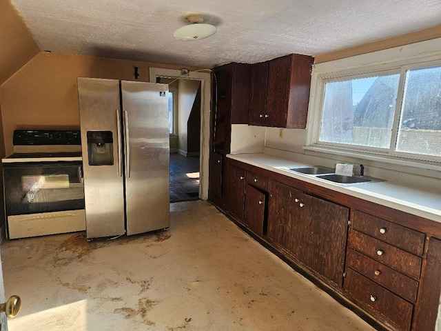 kitchen featuring dark brown cabinetry, electric range, sink, stainless steel fridge, and lofted ceiling