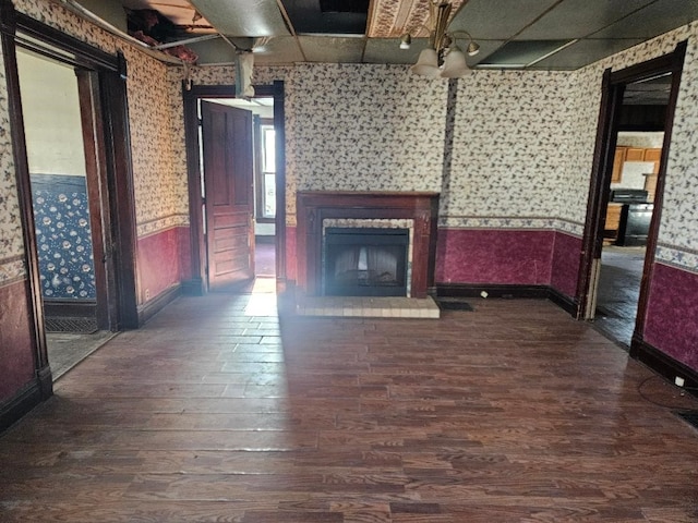 unfurnished living room featuring a fireplace and dark wood-type flooring