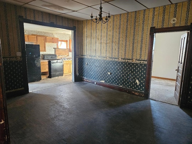 unfurnished dining area featuring hardwood / wood-style floors and an inviting chandelier