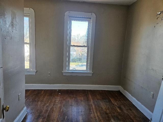 unfurnished room with a wealth of natural light and dark wood-type flooring