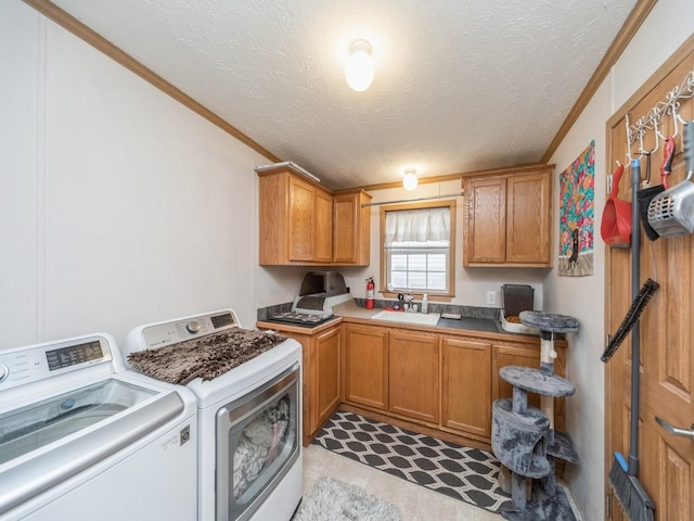 laundry room with cabinets, sink, crown molding, washer and dryer, and a textured ceiling