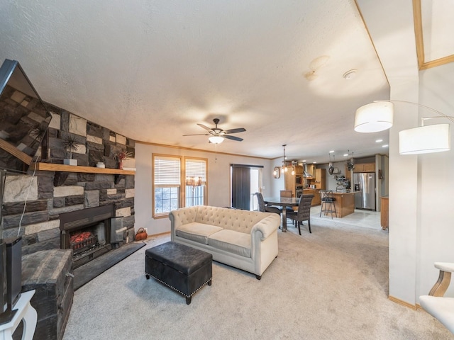 living room with light carpet, a textured ceiling, ceiling fan, crown molding, and a stone fireplace