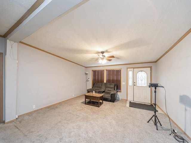 carpeted living room with a textured ceiling, ceiling fan, and crown molding