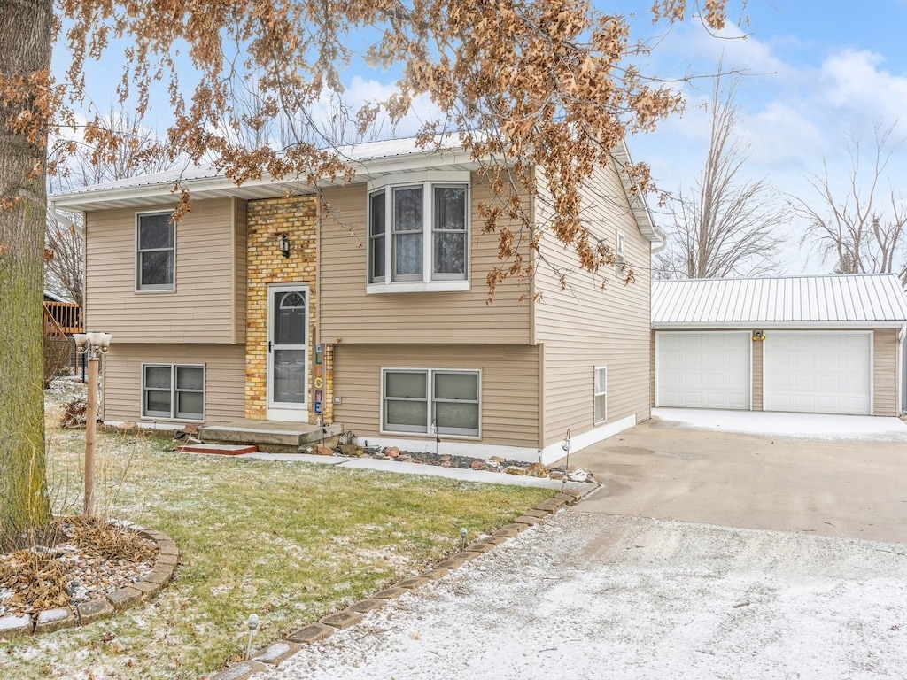 raised ranch featuring an outbuilding, a front yard, and a garage