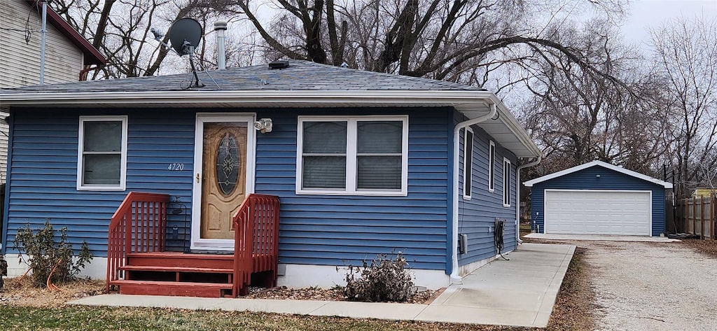 bungalow-style house featuring fence, an outdoor structure, and a garage