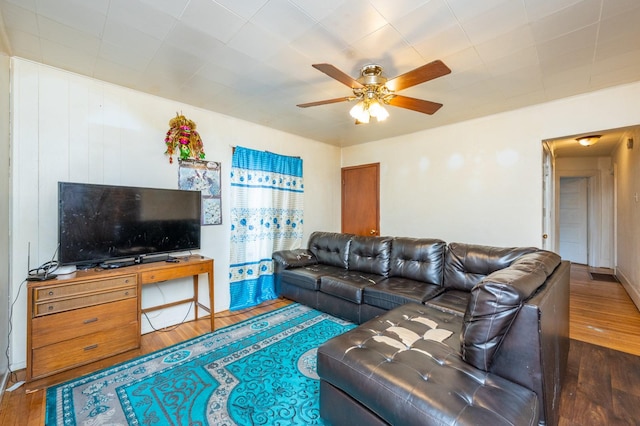 living room with ceiling fan and dark hardwood / wood-style flooring