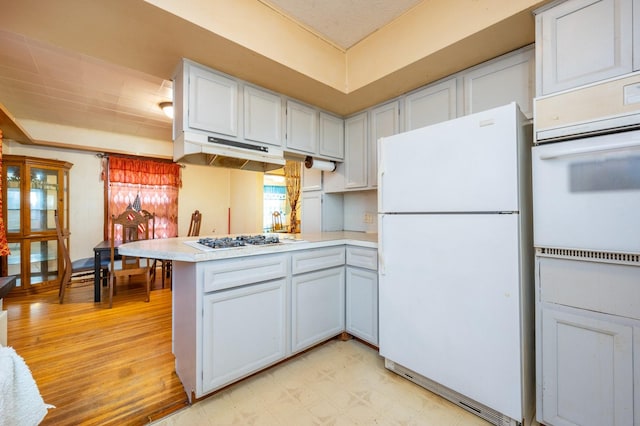 kitchen featuring white cabinets, white appliances, kitchen peninsula, and light hardwood / wood-style flooring