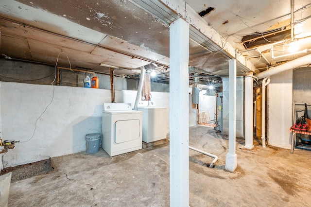 basement with electric panel, water heater, washer and clothes dryer, and heating unit