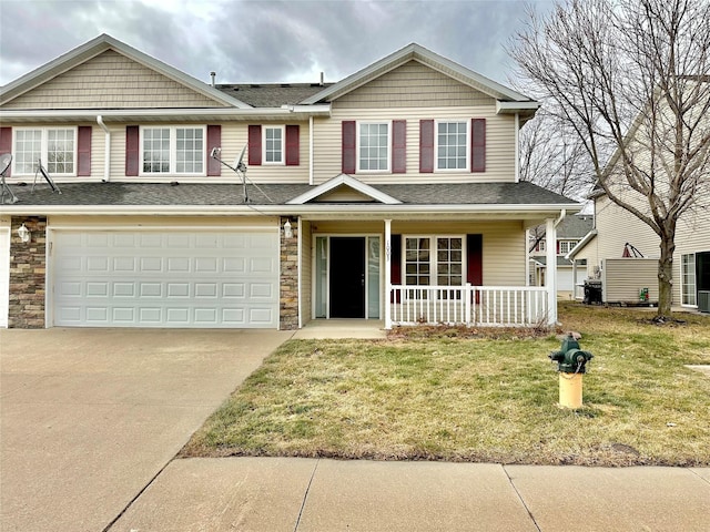 view of front of home featuring a porch, a garage, and a front lawn