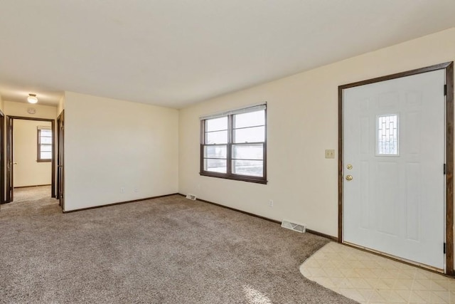 carpeted entryway featuring a healthy amount of sunlight