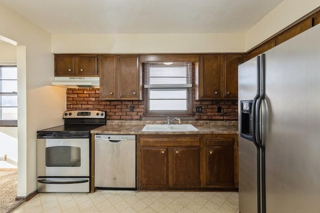 kitchen featuring plenty of natural light, dark brown cabinets, sink, and appliances with stainless steel finishes