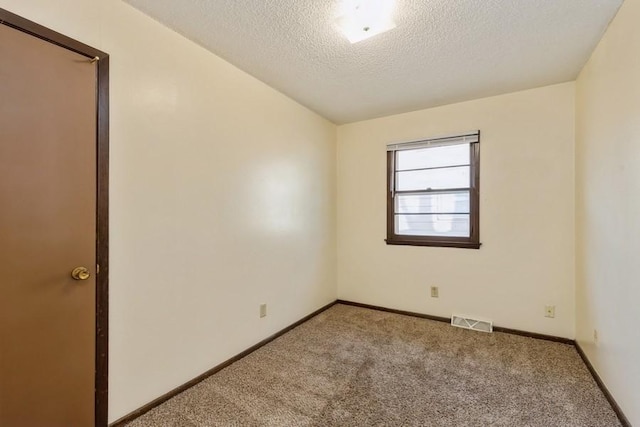 empty room featuring carpet and a textured ceiling