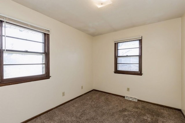 unfurnished room with dark carpet