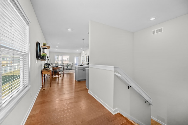 hallway with light hardwood / wood-style floors