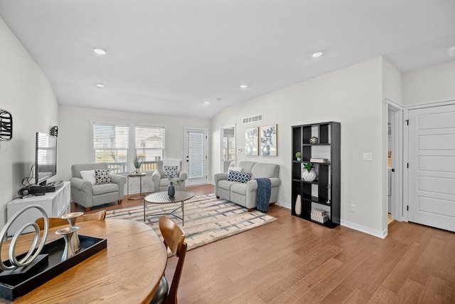 living room with light hardwood / wood-style floors and lofted ceiling