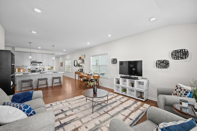 living room with vaulted ceiling and light hardwood / wood-style flooring