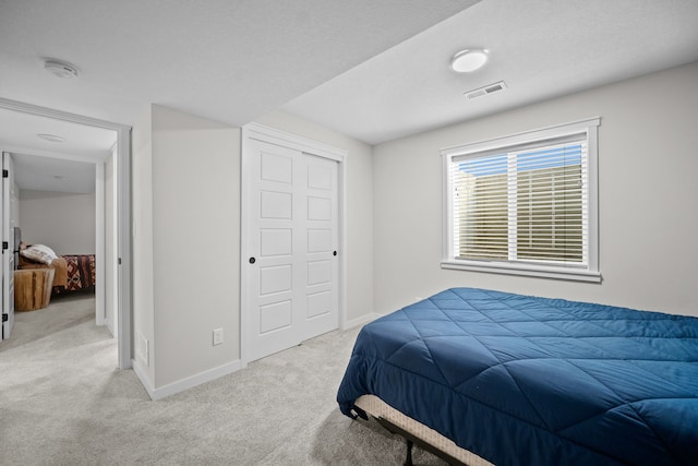 bedroom featuring light colored carpet and a closet