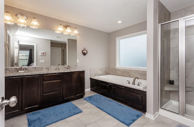 bathroom featuring a sink, a stall shower, double vanity, and a bath