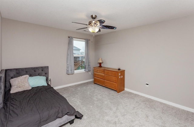 bedroom featuring light colored carpet, ceiling fan, and baseboards