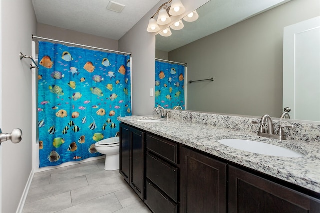 bathroom with toilet, double vanity, visible vents, and a sink