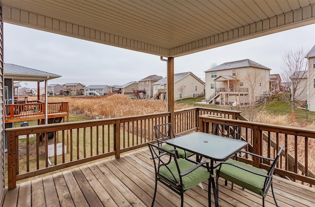 wooden terrace featuring a residential view and outdoor dining area