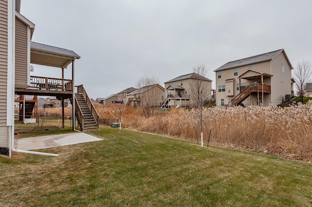 view of yard with a residential view, stairway, and a deck