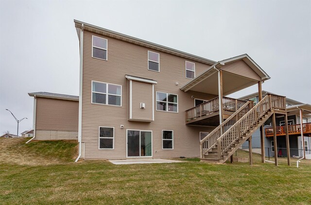 back of house with a lawn and stairs