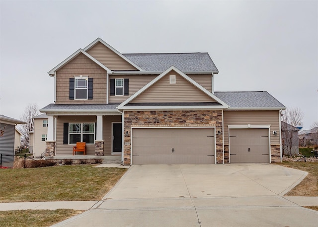 craftsman house featuring a garage, covered porch, and a front yard