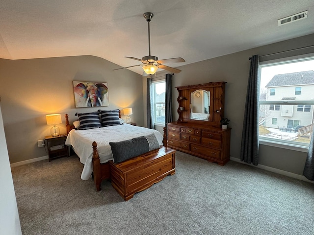 carpeted bedroom featuring lofted ceiling, visible vents, ceiling fan, and baseboards