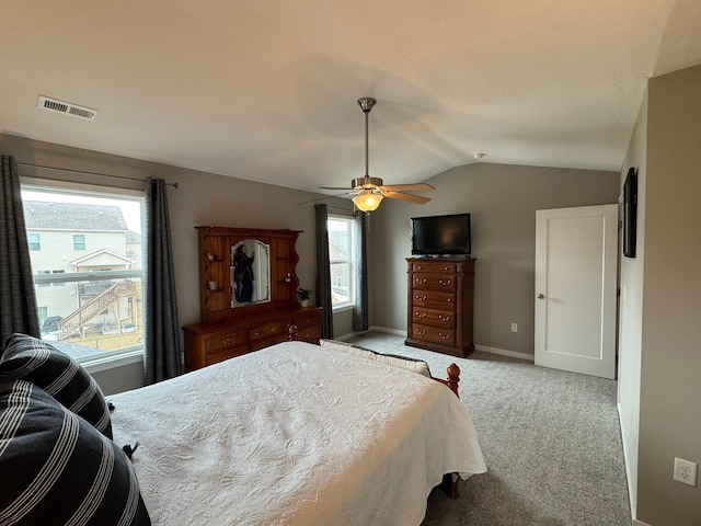 bedroom featuring light colored carpet, a ceiling fan, baseboards, vaulted ceiling, and visible vents