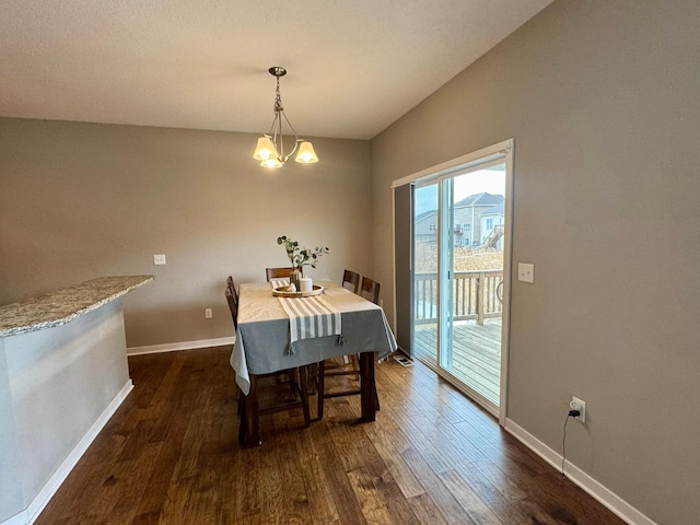 dining room featuring dark wood finished floors, baseboards, and an inviting chandelier