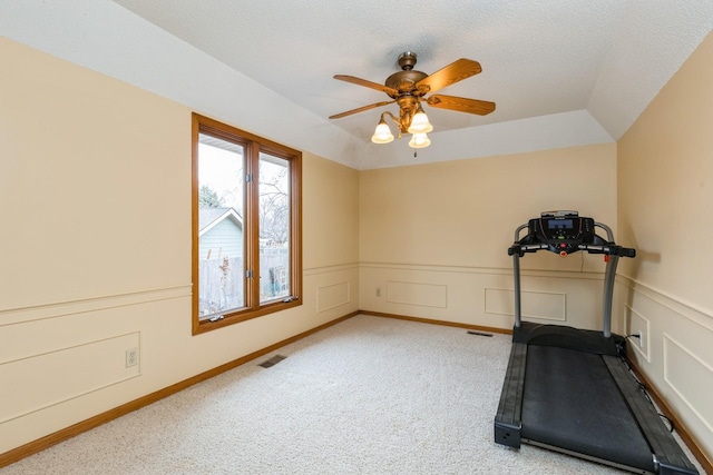 exercise room with ceiling fan, carpet floors, and a textured ceiling