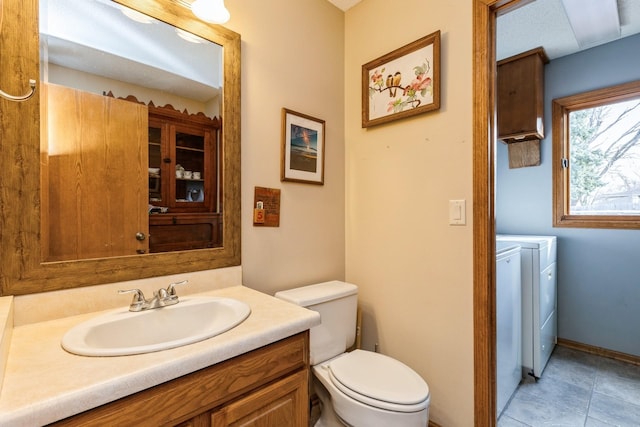 bathroom with separate washer and dryer, vanity, and toilet