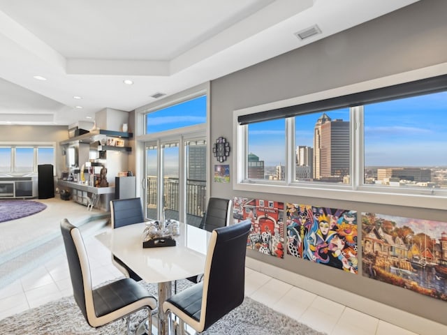 tiled dining area featuring a tray ceiling