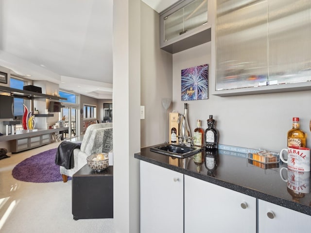 bar featuring sink and white cabinets