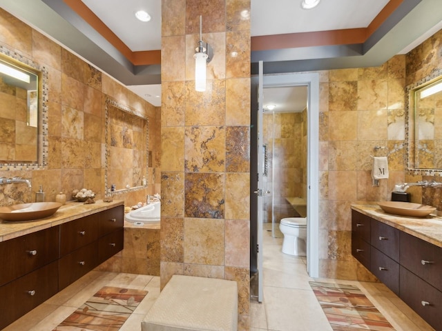 bathroom with tile patterned flooring, vanity, tile walls, and toilet