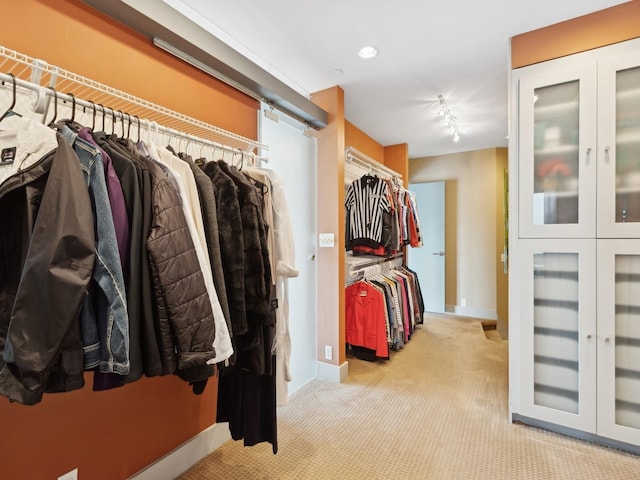 walk in closet with light colored carpet