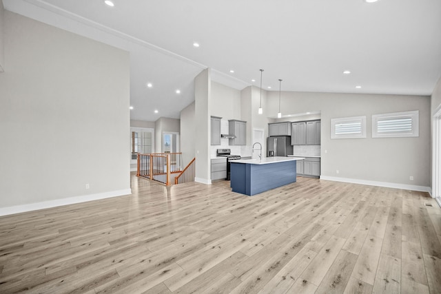 kitchen featuring light countertops, light wood-style flooring, gray cabinetry, appliances with stainless steel finishes, and open floor plan