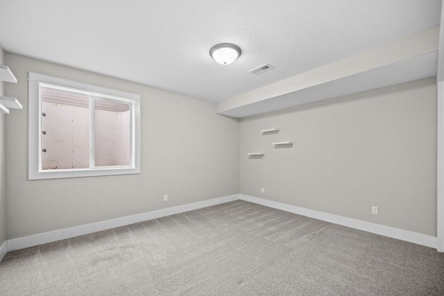 empty room featuring visible vents, carpet flooring, and baseboards