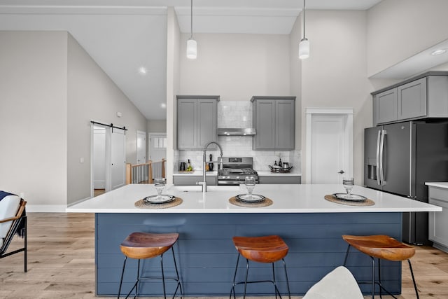 kitchen featuring high vaulted ceiling, appliances with stainless steel finishes, and gray cabinets