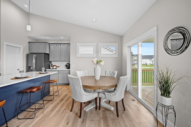 dining area with high vaulted ceiling, recessed lighting, light wood-style flooring, and visible vents