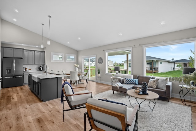 living room featuring light wood-style floors, recessed lighting, plenty of natural light, and high vaulted ceiling