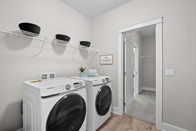 laundry area featuring laundry area, light wood-style floors, baseboards, and separate washer and dryer