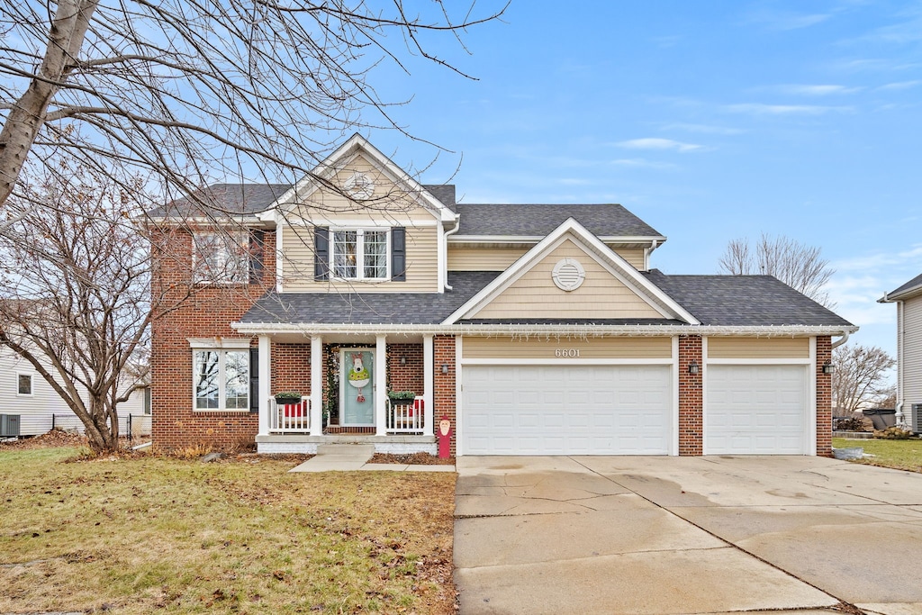 view of front facade featuring a porch, a garage, and a front yard