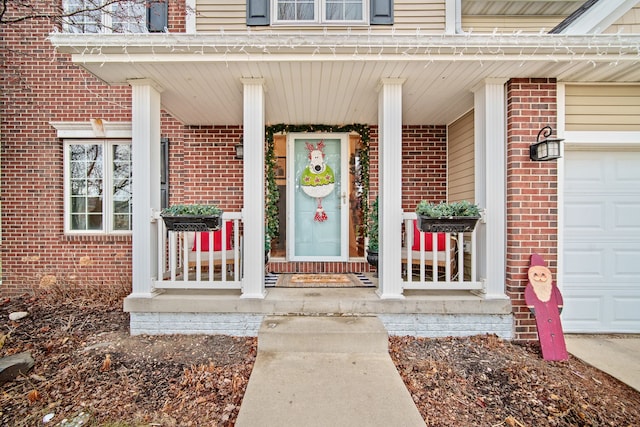 view of exterior entry featuring a porch and a garage