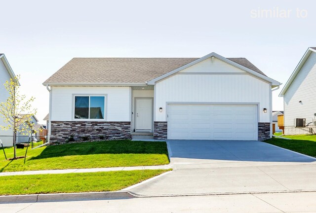 view of front of property with central AC, a garage, and a front lawn